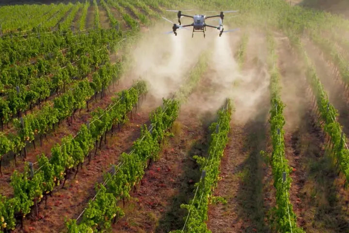 A DJI Agras T100 spraying a field